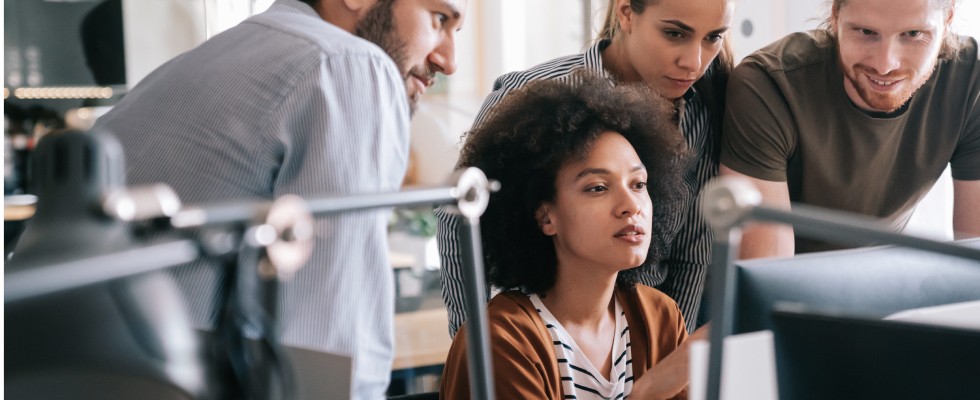 Four people looking at computer