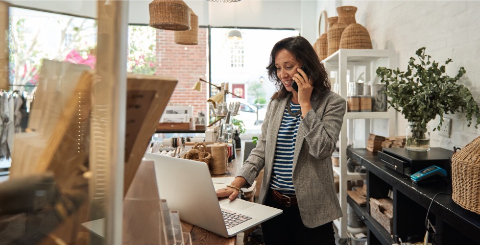 Woman talking on phone and using computer
